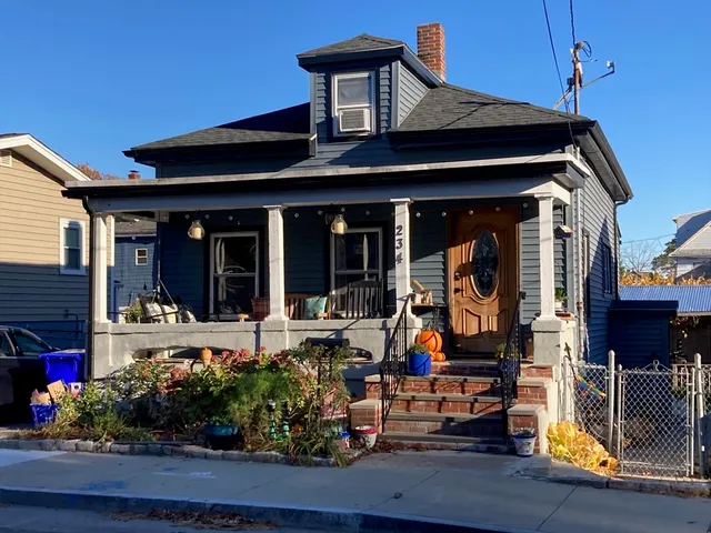 a front view of a house with outdoor seating and potted plants