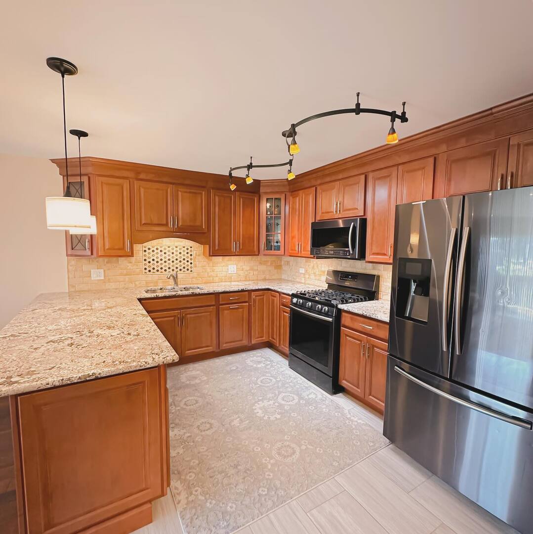 1575 Sandpebble Drive, Unit 104 Wheeling, IL 60090 - Photo 2 of 8 a kitchen with stainless steel appliances granite countertop a refrigerator a stove a sink and a microwave