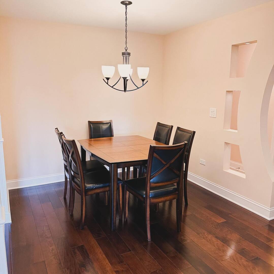 1575 Sandpebble Drive, Unit 104 Wheeling, IL 60090 - Photo 3 of 8 a view of a dining room with furniture wooden floor and chandelier