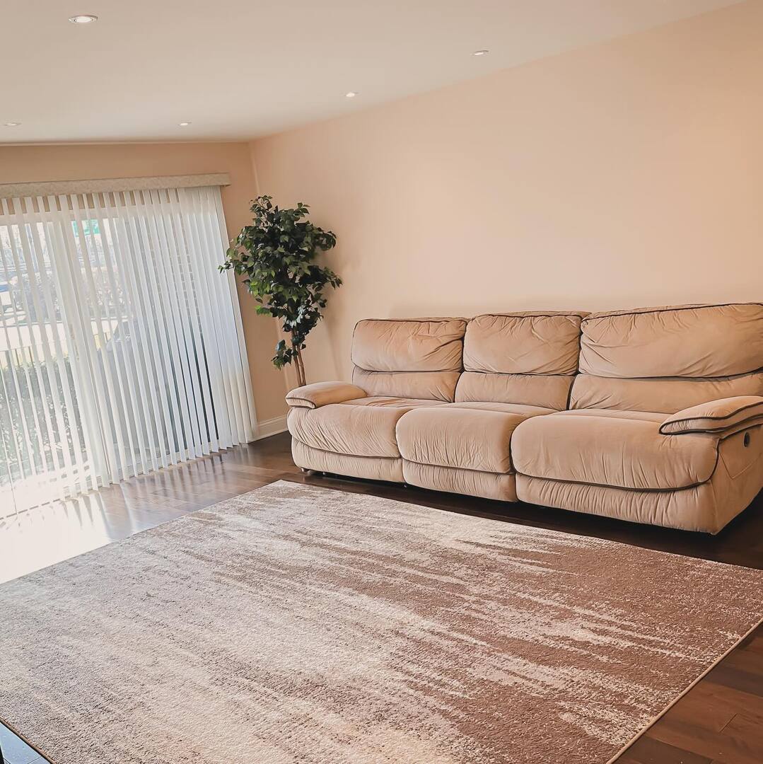 1575 Sandpebble Drive, Unit 104 Wheeling, IL 60090 - Photo 4 of 8 a living room with a couch and a potted plant