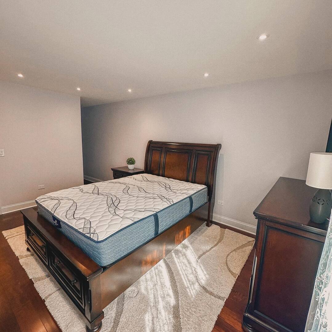 1575 Sandpebble Drive, Unit 104 Wheeling, IL 60090 - Photo 5 of 8 a bedroom with a bed and wooden floor