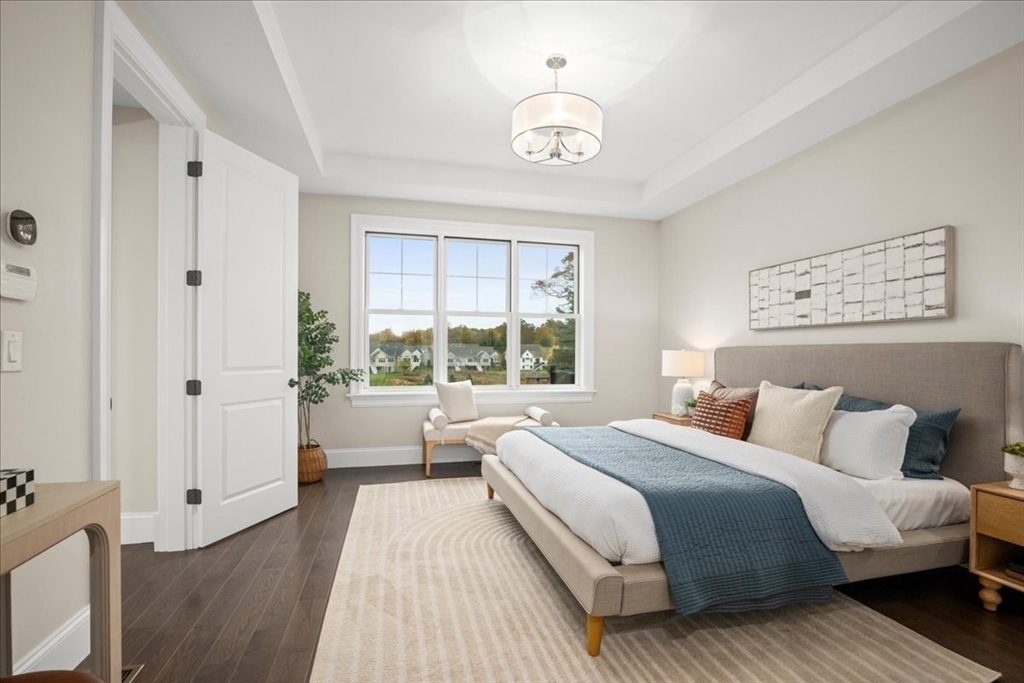 9 Hawk Lane, Unit 28 Framingham, MA 01701 - Photo 12 of 37 a bedroom with a large bed and a chandelier
