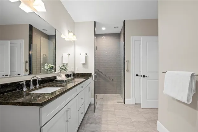 a bathroom with a granite countertop sink and a mirror