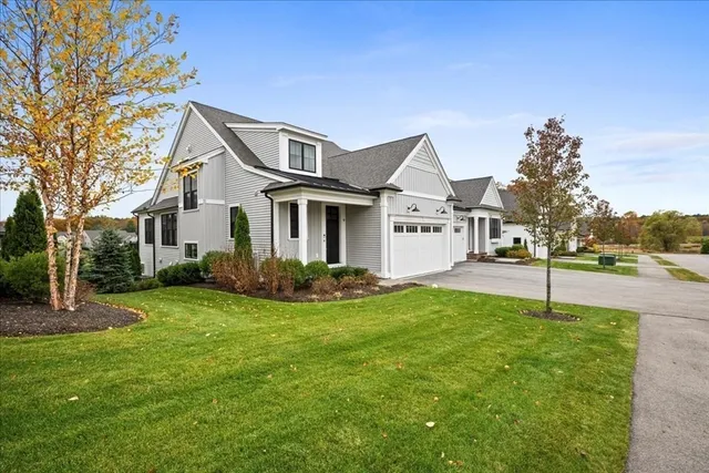 a white house with a small yard and big trees