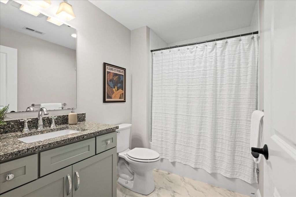 9 Hawk Lane, Unit 28 Framingham, MA 01701 - Photo 27 of 37 a bathroom with a granite countertop toilet sink and mirror