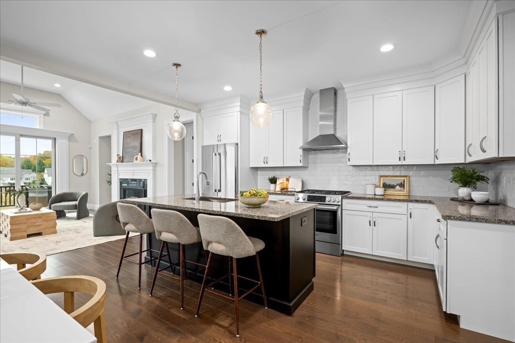 9 Hawk Lane, Unit 28 Framingham, MA 01701 - Photo 3 of 37 a kitchen with stainless steel appliances granite countertop a table chairs stove and white cabinets
