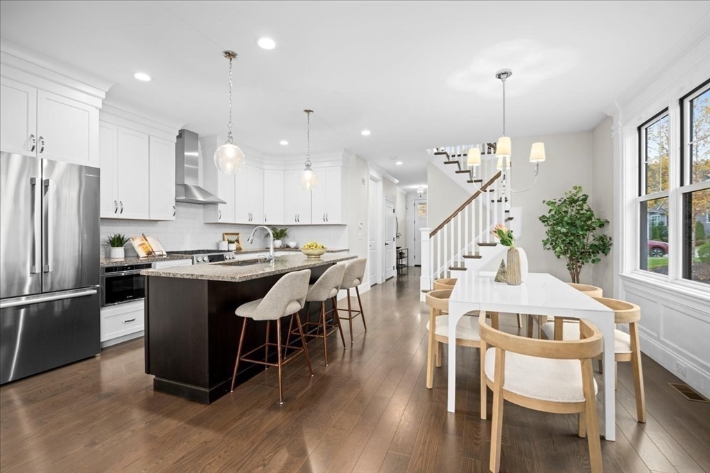 9 Hawk Lane, Unit 28 Framingham, MA 01701 - Photo 4 of 37 a kitchen with stainless steel appliances kitchen island granite countertop a table chairs and a refrigerator