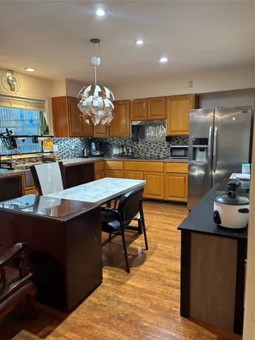 a kitchen with a kitchen island wooden cabinets and refrigerator