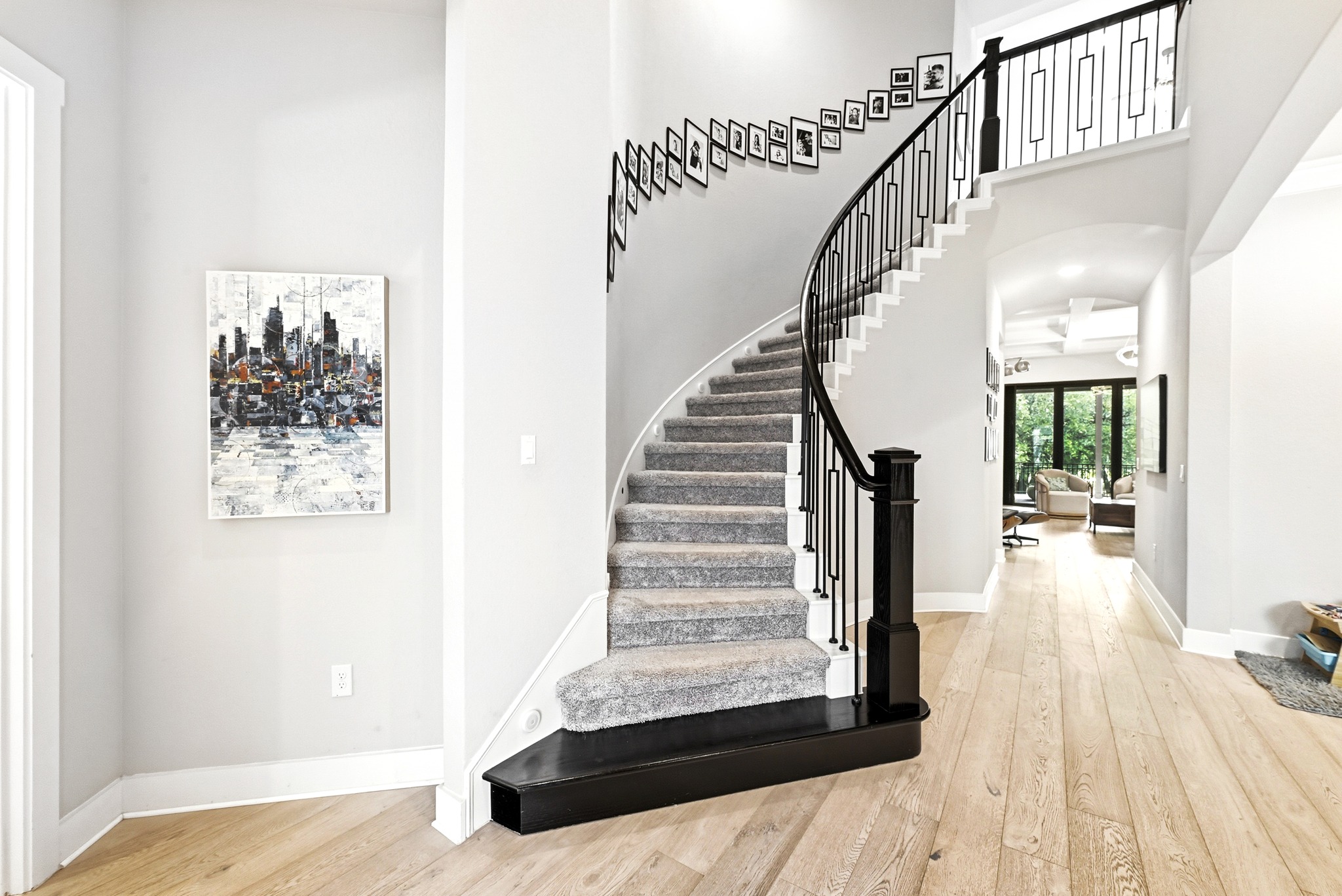 9008 Harper Rae Drive Austin, TX 78717 - Photo 5 of 39 Gracious entry featuring a curved staircase with black wrought iron spindles and a carpeted tread