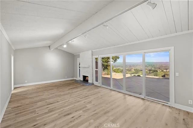 a view of an empty room with a fireplace and a window