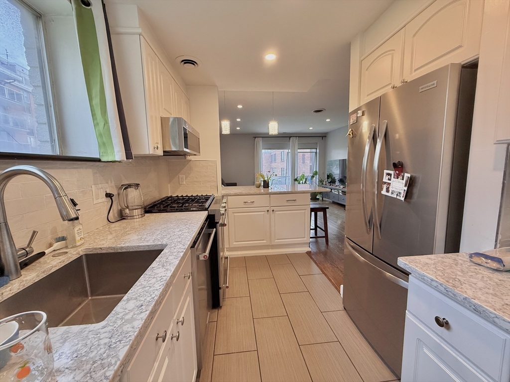 20 Stearns Road, Unit 45 Brookline, MA 02446 - Photo 4 of 22 a kitchen with stainless steel appliances granite countertop a sink stove and refrigerator