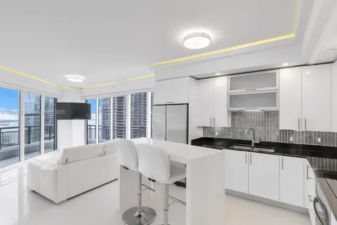 a kitchen with granite countertop a sink and white cabinets