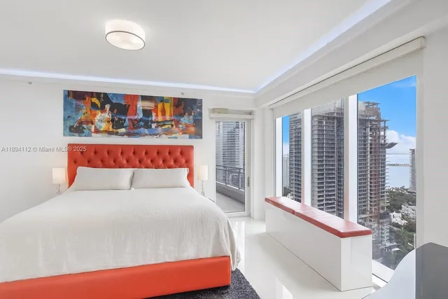 a bedroom with furniture and a large window