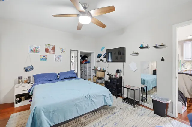 a bedroom with a bed and a flat tv screen on the dresser