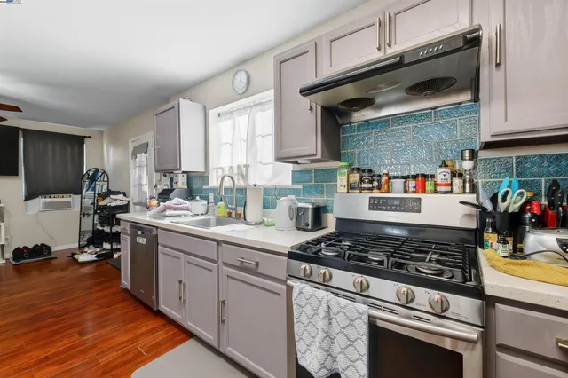 a living room with furniture a flat screen tv and kitchen view