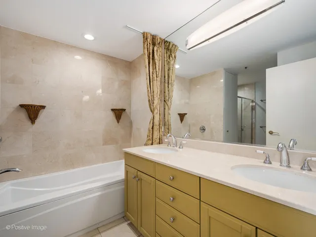 a bathroom with a granite countertop sink mirror toilet and bathtub