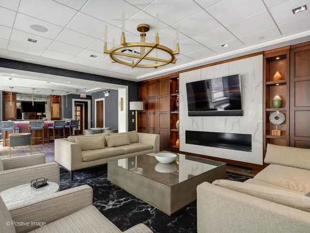 a living room with furniture a flat screen tv and kitchen view