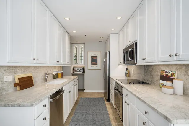 a kitchen with stainless steel appliances granite countertop a sink stove and refrigerator