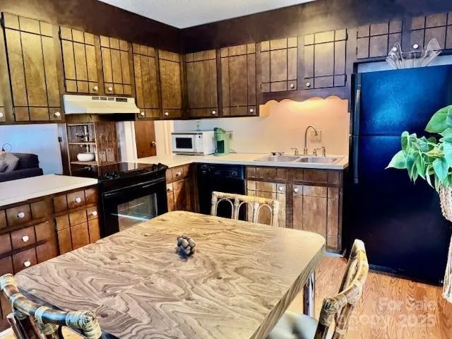 a kitchen with stainless steel appliances kitchen island granite countertop a sink a stove and a wooden cabinets