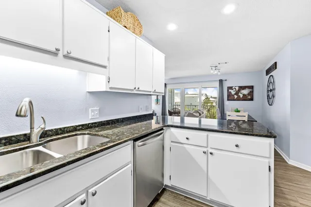 a kitchen with granite countertop white cabinets and white appliances
