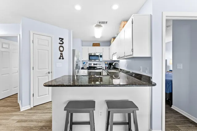 a kitchen with stainless steel appliances granite countertop a stove a sink and a refrigerator