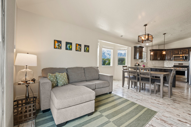 8248 South Resaca Drive, Unit J10 Sandy, UT 84070 - Photo 8 of 40 Open-concept living space featuring wood-finish flooring, recessed lighting, and large windows