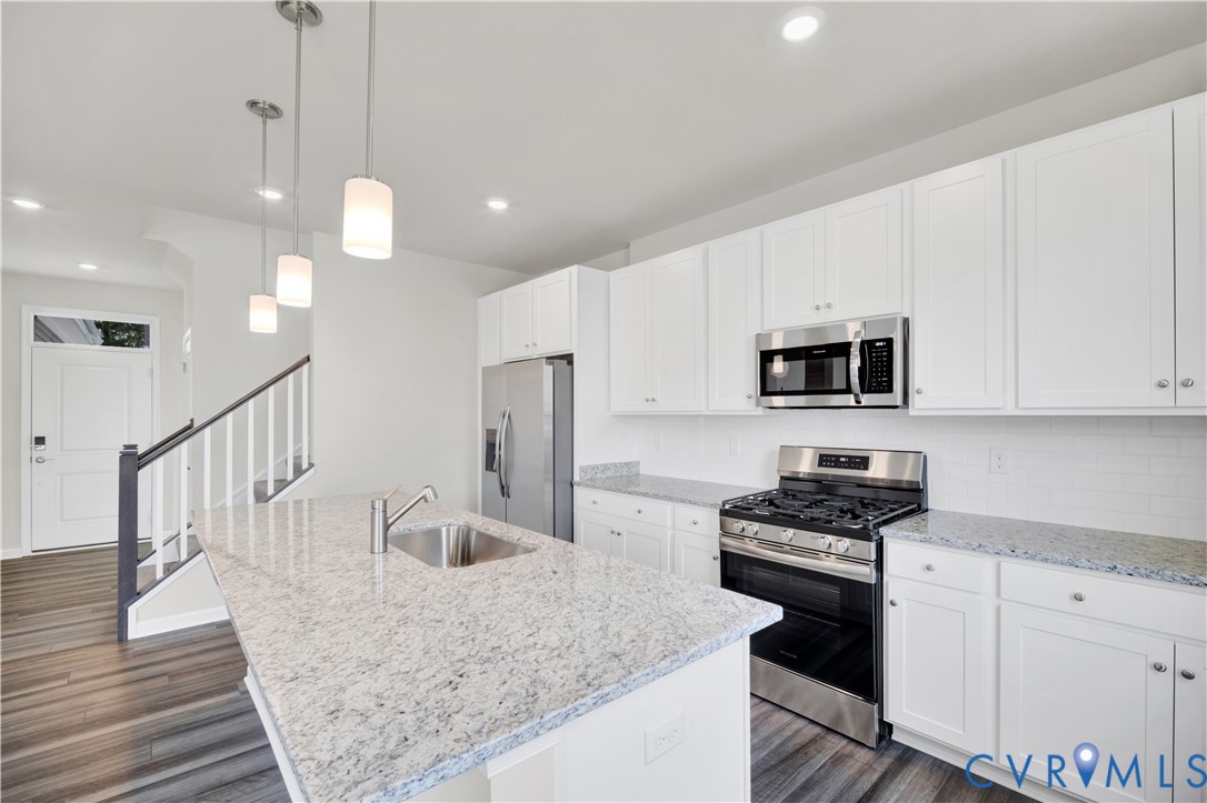 6612 Cassia Loop Moseley, VA 23120 - Photo 5 of 19 a kitchen with stainless steel appliances granite countertop a stove a sink and a refrigerator