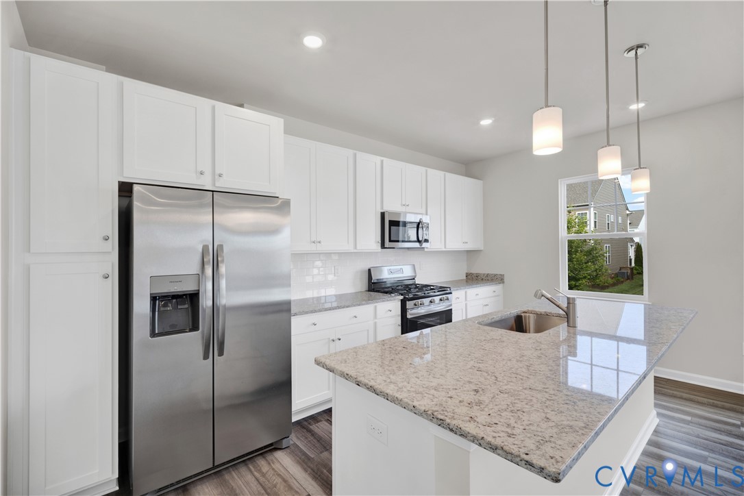 6612 Cassia Loop Moseley, VA 23120 - Photo 6 of 19 a kitchen with stainless steel appliances granite countertop a refrigerator a sink a stove and a center island