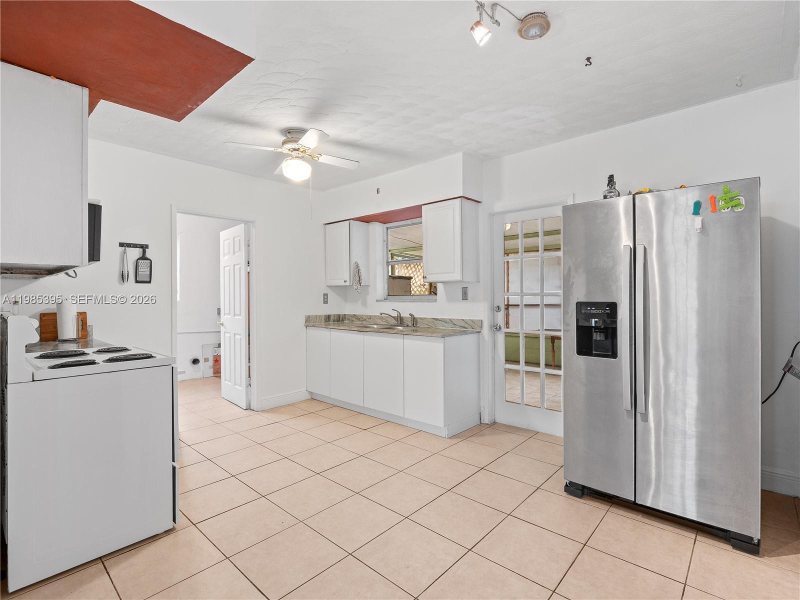 a kitchen with stainless steel appliances a refrigerator sink and white cabinets