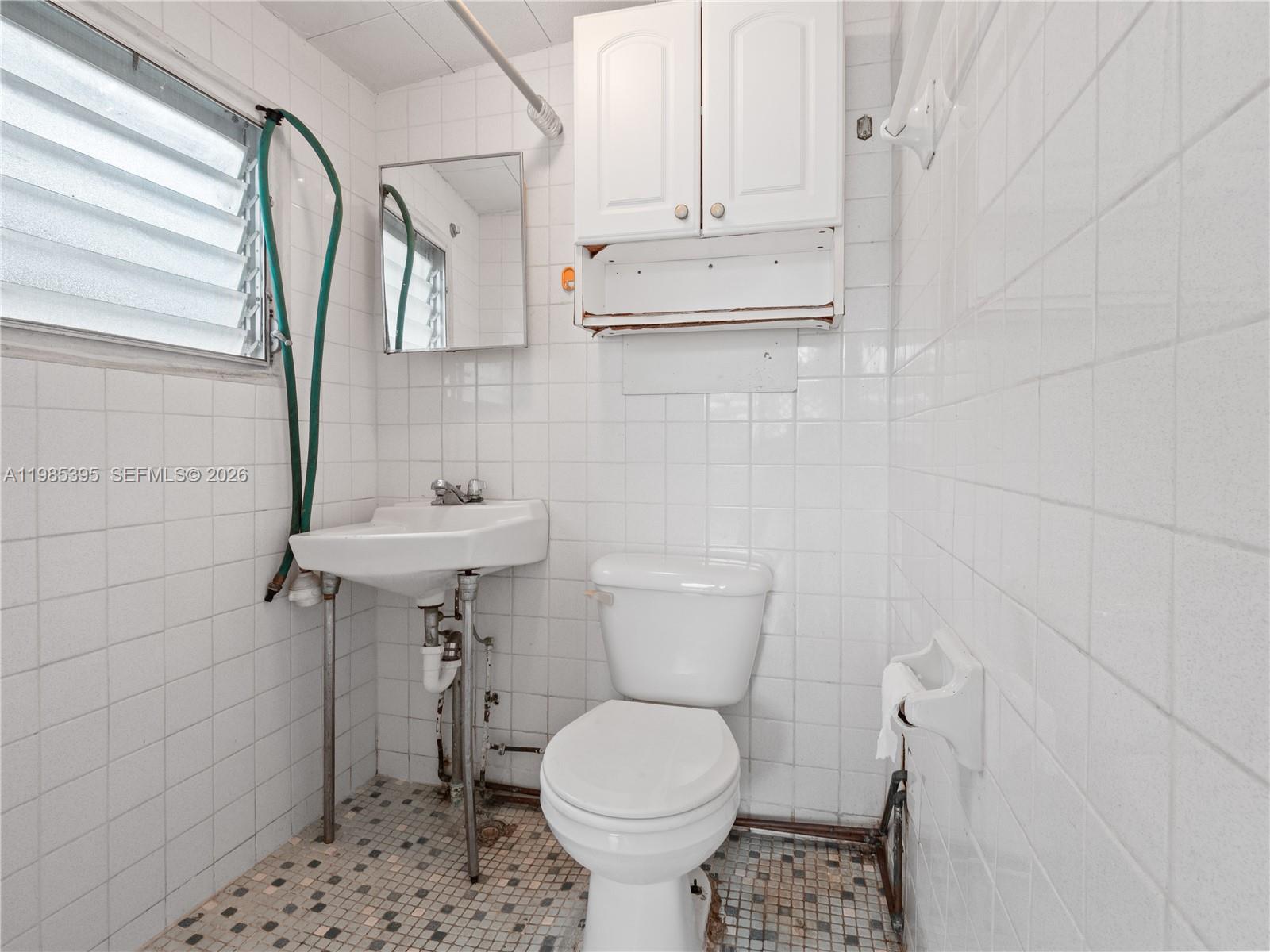 6111 Southwest 20th Court Miramar, FL 33023 - Photo 25 of 31 a bathroom with a toilet sink and mirror
