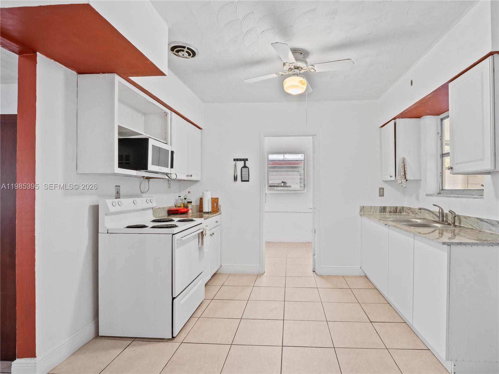 6111 Southwest 20th Court Miramar, FL 33023 - Photo 9 of 31 a kitchen with stainless steel appliances a stove top oven a sink a refrigerator and white cabinets