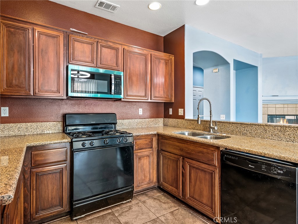 14400 Jeremiah Street Adelanto, CA 92301 - Photo 11 of 45 a kitchen with stainless steel appliances granite countertop a stove microwave and sink