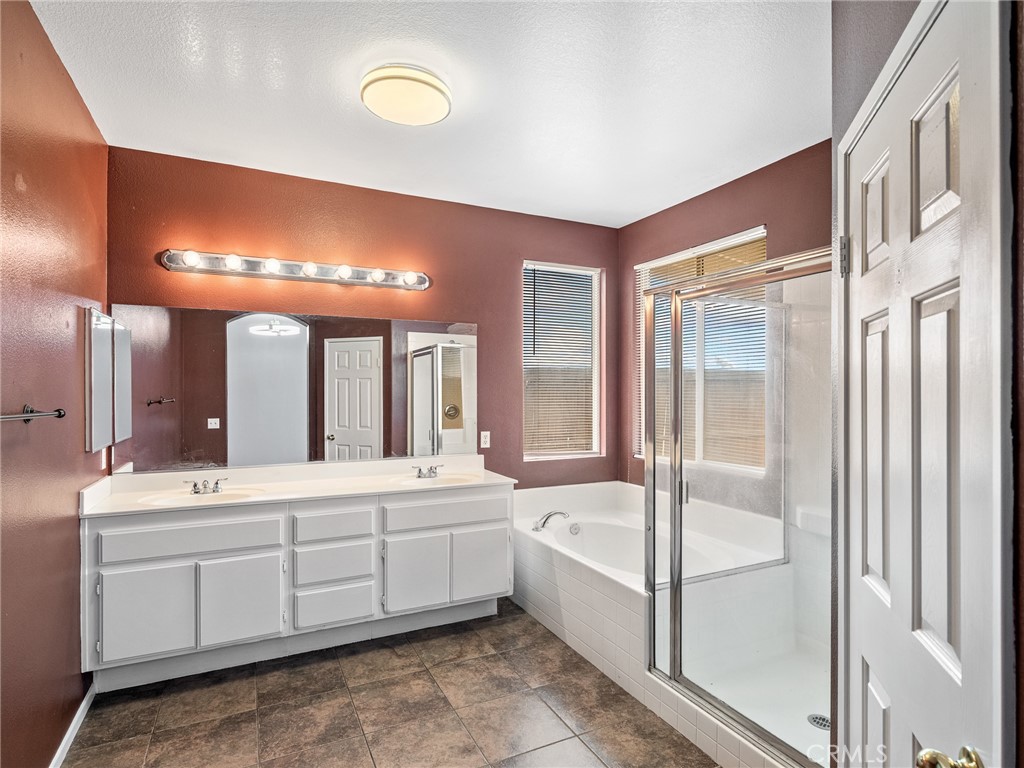 14400 Jeremiah Street Adelanto, CA 92301 - Photo 29 of 45 a bathroom with a double vanity sink a mirror and a bathtub