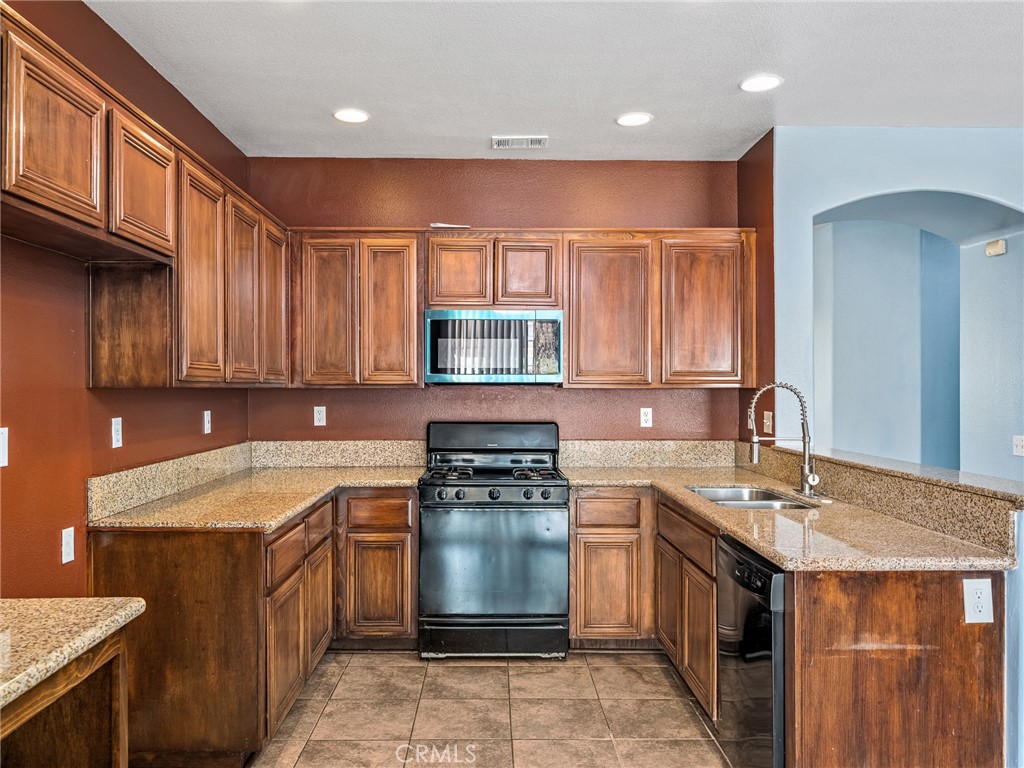 14400 Jeremiah Street Adelanto, CA 92301 - Photo 10 of 45 a kitchen with a sink stove top oven and cabinets