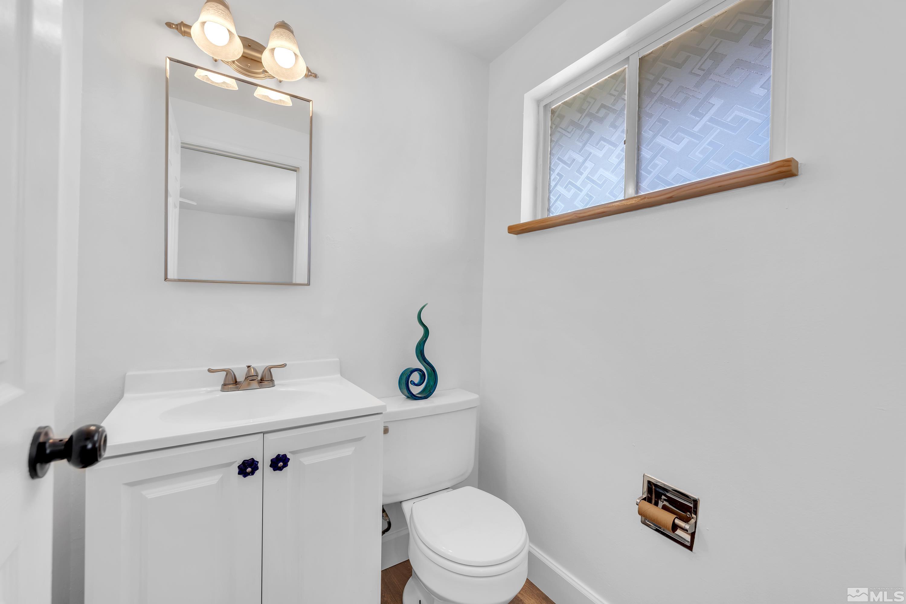 635 Wiggins Court Reno, NV 89506 - Photo 9 of 20 a bathroom with a toilet sink vanity and mirror