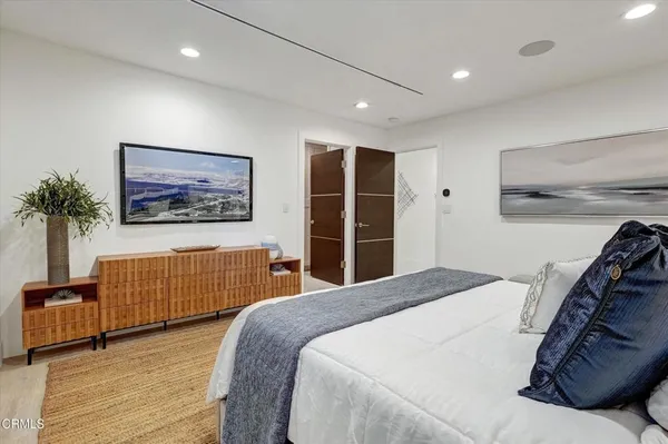 a bedroom with a large bed and a potted plant