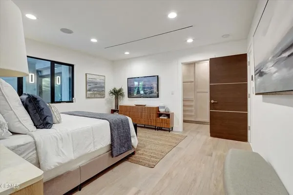 a bedroom with a large bed and a chandelier