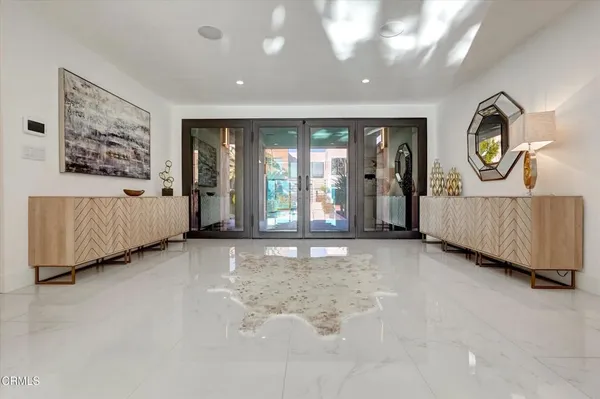 a view of a hallway with entryway and bedroom with wooden floor