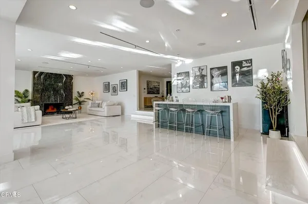 a living room with furniture a large window and potted plants