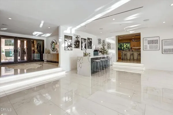 a living room with furniture potted plant and kitchen view