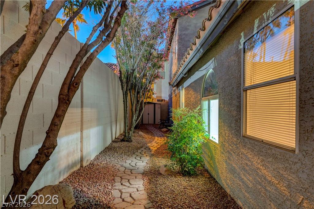2283 Ramsgate Drive Henderson, NV 89074 - Photo 47 of 51 A stone pathway guides steps through a landscaped side yard bordered by a high wall.