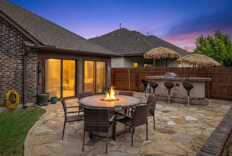 a view of a patio with a table and chairs under an umbrella
