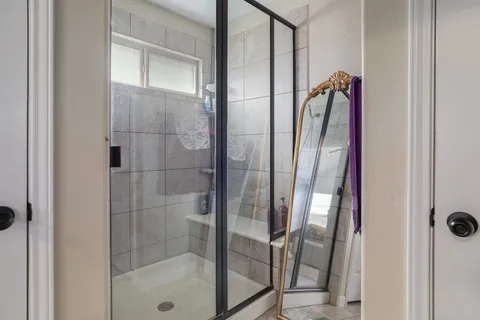 a bathroom with a glass shower door and mirror