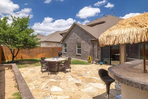 a view of a house with backyard and sitting area