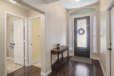 a view of a hallway with wooden floor and furniture