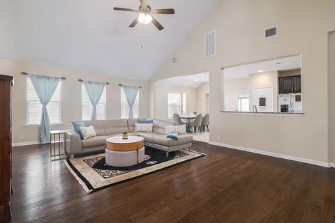 a living room with furniture and wooden floor