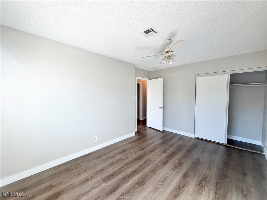 6401 Waterthrush Way Las Vegas, NV 89103 - Photo 12 of 19 Unfurnished bedroom featuring wood finished floors, a textured ceiling, a closet, and ceiling fan