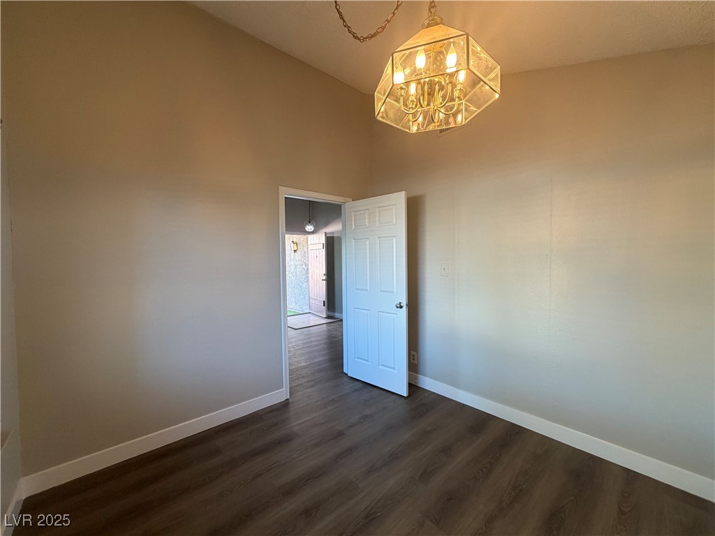 6401 Waterthrush Way Las Vegas, NV 89103 - Photo 19 of 19 Unfurnished room featuring dark wood-type flooring, a chandelier, and high vaulted ceiling