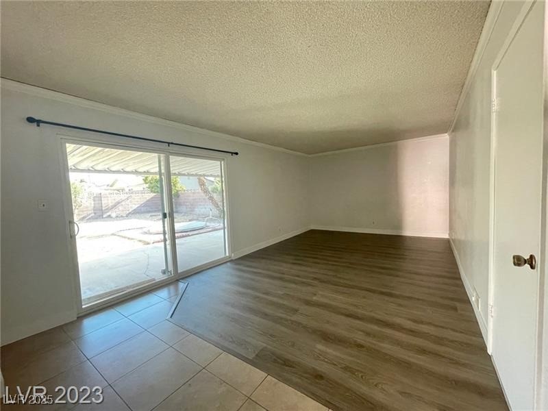 6401 Waterthrush Way Las Vegas, NV 89103 - Photo 2 of 19 Spare room with ornamental molding, tile patterned floors, and a textured ceiling