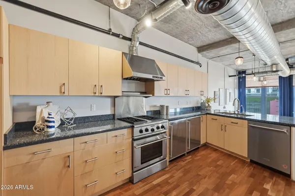 a kitchen with stainless steel appliances granite countertop a stove a sink and white cabinets